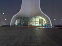 a building with a tall dome shaped structure with several lights on top of it in front of a night sky