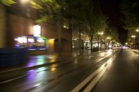 a blurry picture of cars on the street at night with buildings in the background