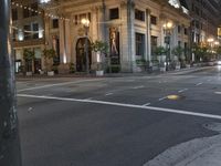 the lights on the street are reflecting off of the buildings at night time as if at an intersection