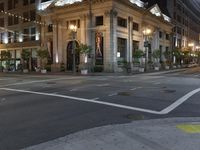 the lights on the street are reflecting off of the buildings at night time as if at an intersection