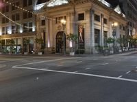 the lights on the street are reflecting off of the buildings at night time as if at an intersection