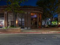 a city street at night with parking meters on either side and the road in the center