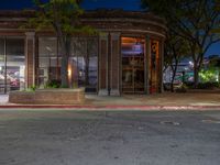 a city street at night with parking meters on either side and the road in the center