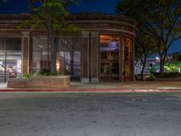 a city street at night with parking meters on either side and the road in the center