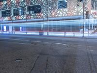 an empty street near a building at night with no traffic lights in the foreground