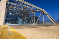 a bridge crossing over a river at night with skyscrapers in the background in this image