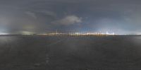 there is an empty airport with a cloud sky in the background and an industrial area at night