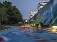 a skate board park in the middle of a city at night with colorful paint all over it