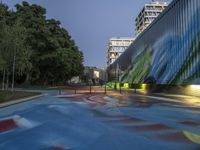 a skate board park in the middle of a city at night with colorful paint all over it