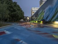 a skate board park in the middle of a city at night with colorful paint all over it