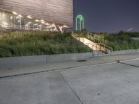 a person skateboard on a concrete surface near stairs in a park setting at night