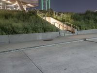 a person skateboard on a concrete surface near stairs in a park setting at night