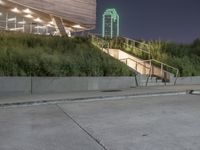 a person skateboard on a concrete surface near stairs in a park setting at night