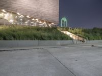 a person skateboard on a concrete surface near stairs in a park setting at night