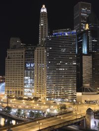 the city's skyline is lit up and the water is moving by itself in the dark