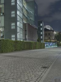 a man skateboards past an office building with glass walls and privacy panels behind him