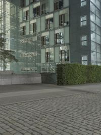 a man skateboards past an office building with glass walls and privacy panels behind him