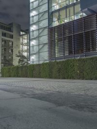 a man skateboards past an office building with glass walls and privacy panels behind him