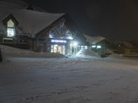 an outside snowy market at night during the winter months and a person stands with skis in hand