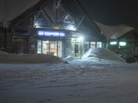 an outside snowy market at night during the winter months and a person stands with skis in hand