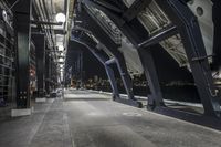 an empty walkway is in an industrial building with a bench and lamp poles for people