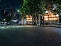 a street with several rows of lamps on either side of the road, two people crossing over a street