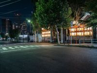 a street with several rows of lamps on either side of the road, two people crossing over a street