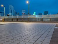 people standing on a subway platform with many buildings in the background at night light in tokyo