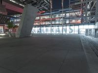 an outdoor space features glass walls and columns at night, with light streaming through the glass walls