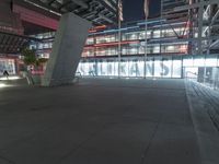 an outdoor space features glass walls and columns at night, with light streaming through the glass walls