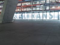 an outdoor space features glass walls and columns at night, with light streaming through the glass walls