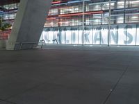 an outdoor space features glass walls and columns at night, with light streaming through the glass walls