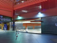 there are lights on the ceiling above a building as an empty mat lies in front of it