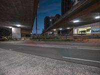 a city view at night shows highway and elevated roadway with urban lights in the background