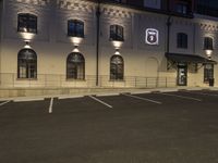 a parking lot with two brick buildings and a sign that reads 3, on the front of it