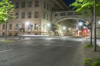 a long exposure photograph of the street and building at night and looking down at a street corner