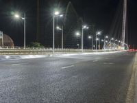 street lights on an empty highway next to a building at night or during the night