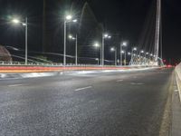 street lights on an empty highway next to a building at night or during the night