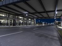 empty road with cars on both sides and an airport in the background, at night