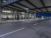 empty road with cars on both sides and an airport in the background, at night