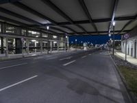 empty road with cars on both sides and an airport in the background, at night