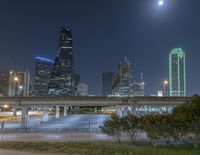 view of the city and freeway highway in a nighttime sky with bright lights over the bridge, at night