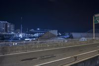 a freeway sign on the side of a road at night by a body of water