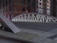 a pedestrian bridge over an empty street during night time, with no people in view