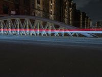 a pedestrian bridge over an empty street during night time, with no people in view