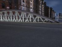 a pedestrian bridge over an empty street during night time, with no people in view