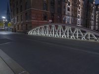a pedestrian bridge over an empty street during night time, with no people in view