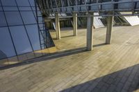 the shadow of someone walking on a sidewalk at night under a building with a skylight