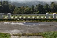 a bench in front of a railing on a hill top with pine trees on it