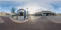 fisheye photograph of a city street with stores and sidewalks in it as seen on a google maps video